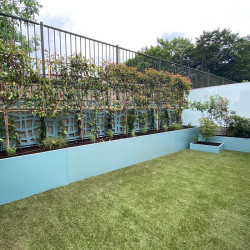 Installation de bacs de jardin peints bleus dans un jardin, esthétique nette et travaillée, rapide à installer.